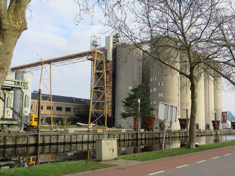 De silo’s en de oranje transportbrug van de Noordkade in Veghel, gezien vanaf het fietspad langs de haven